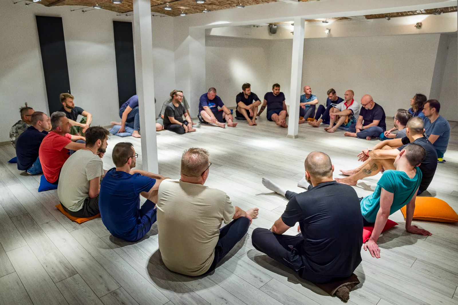Krąg mężczyzn na warsztacie LOWEN for MEN, siadanie na poduszkach przed kolejnym blokiem pracy